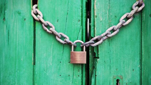 A clean padlock on a green door.
