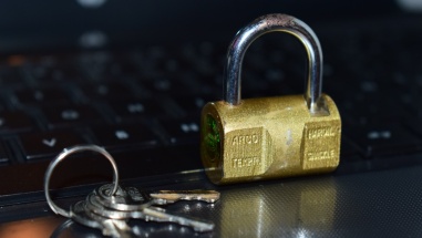 A gold padlock sits in front of a laptop keyboard.